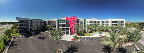 a building with palm trees in front of it at Pinnacle Apartments, Jacksonville, FL